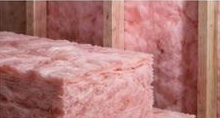 Pink fiberglass insulation batts between studs